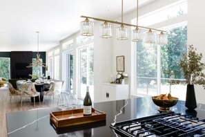 A modern kitchen with a marble countertop, a wine bottle, and a fruit bowl. - Emerald Acres, an elevated Retreat on Five Private Acres (Bellingham)