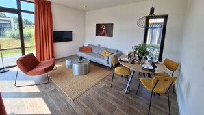 Ein modernes Wohnzimmer mit Sofa, Couchtisch, Esstisch und Stühlen.