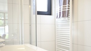 Ein Badezimmer mit einem weißen Waschbecken, einem Fenster mit Jalousien und einem Handtuchhalter.