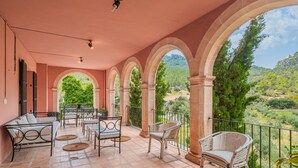 A covered patio with a view of a mountainous landscape, featuring a sofa, chairs, and a table. - Holiday Villa 'Villa Son Perot' with Mountain Views, Private Pool and Wi-Fi (Orient)