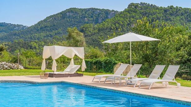 A swimming pool with lounge chairs and umbrellas, surrounded by greenery and mountains. - Holiday Villa 'Villa Son Perot' with Mountain Views, Private Pool and Wi-Fi (Orient)