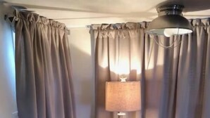 Ein runder Holztisch mit einem Seestern, einer Lampe und einem Korb voller Zeitschriften.