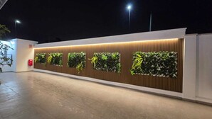 En moderne bygning med flere vertikale haver og en brandhane.