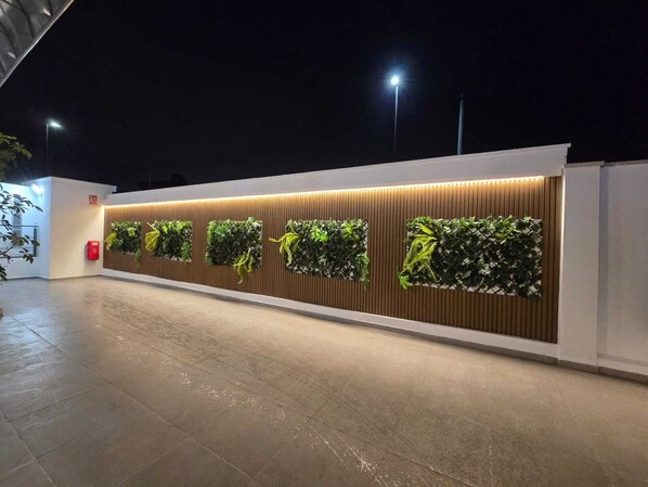 A modern building exterior with a series of vertical gardens and a fire hydrant.