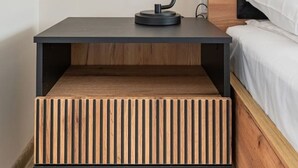 Ein moderner Nachttisch mit integrierter Bank, einer Lampe und einer Nachttischleuchte.