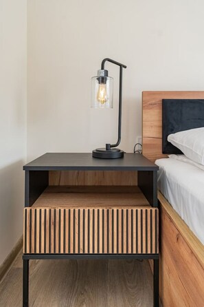 Une table de chevet moderne dotée d’un banc intégré, d’une lampe et d’une lampe de chevet.
