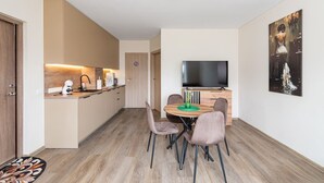 Eine moderne Wohnung mit Küche, Essbereich und Fernseher.