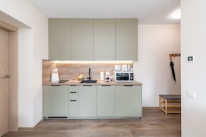 Une cuisine moderne avec des meubles de couleur claire, un plan de travail et un four à micro-ondes.