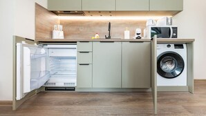 A compact kitchen with built-in appliances, including a dishwasher, a microwave, and a washing machine.