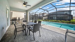 Un portico coperto con piscina, mobili da esterno e vista sulle case vicine.