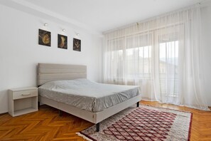Ein Schlafzimmer mit einem Bett, einem Nachttisch und einem gemusterten Teppich.