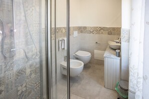A bathroom with a shower, two toilets, a sink, and a trash bin. - At the Court of the Gods - Zeus's Chamber (Tropea)