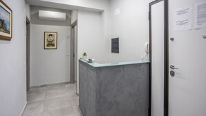 A hallway with a reception desk, a framed picture on the wall, and a door with a notice. - At the Court of the Gods - Aphrodite Room (Tropea)