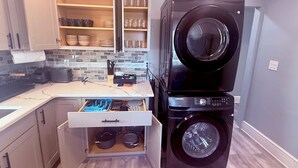 Eine kleine Küche mit integriertem Waschtrockner, einer Arbeitsplatte mit Toaster und einer Schublade für Töpfe.