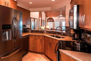 A modern kitchen with stainless steel appliances, wooden cabinets, a granite countertop, and a built-in dishwasher. - 2-bedroom condo with delightful pool and Gulf view.
Sept. 5-12. Week 36. (Key West)