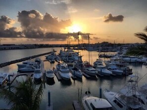 A marina with multiple boats docked, a clear sky, and a sunset. - 2-bedroom condo with delightful pool and Gulf view.
Sept. 5-12. Week 36. (Key West)