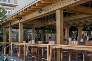 An outdoor wooden pergola with seating, a table, and a security camera. - 2-bedroom condo with delightful pool and Gulf view.
Sept. 5-12. Week 36. (Key West)