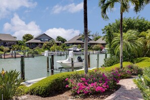 A marina with a docked boat, a pathway, and a row of houses with balconies.