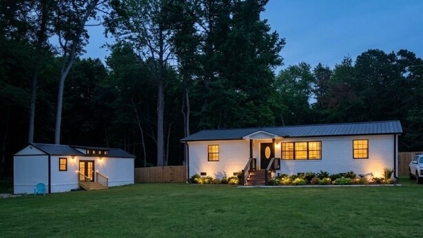 A two-story house with a front porch, a small attached garage, and a well-maintained lawn. - Petite Palace: Guest home in Louisburg, NC (Louisburg)