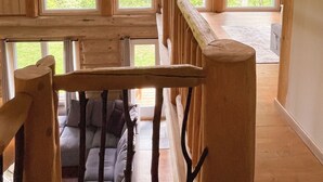 Un intérieur en bois avec un plafond en pente, de nombreuses fenêtres et un escalier.