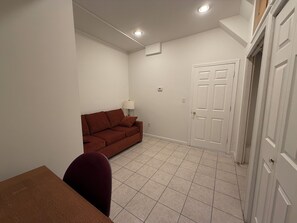Ein Zimmer mit einem braunen Sofa, einem Esstisch und einer weißen Tür.