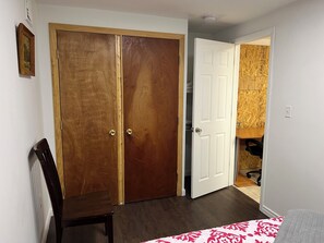 Ein Zimmer mit einem Holzschrank, einer weißen Tür, einem Heizkörper und einem gemusterten Teppich.