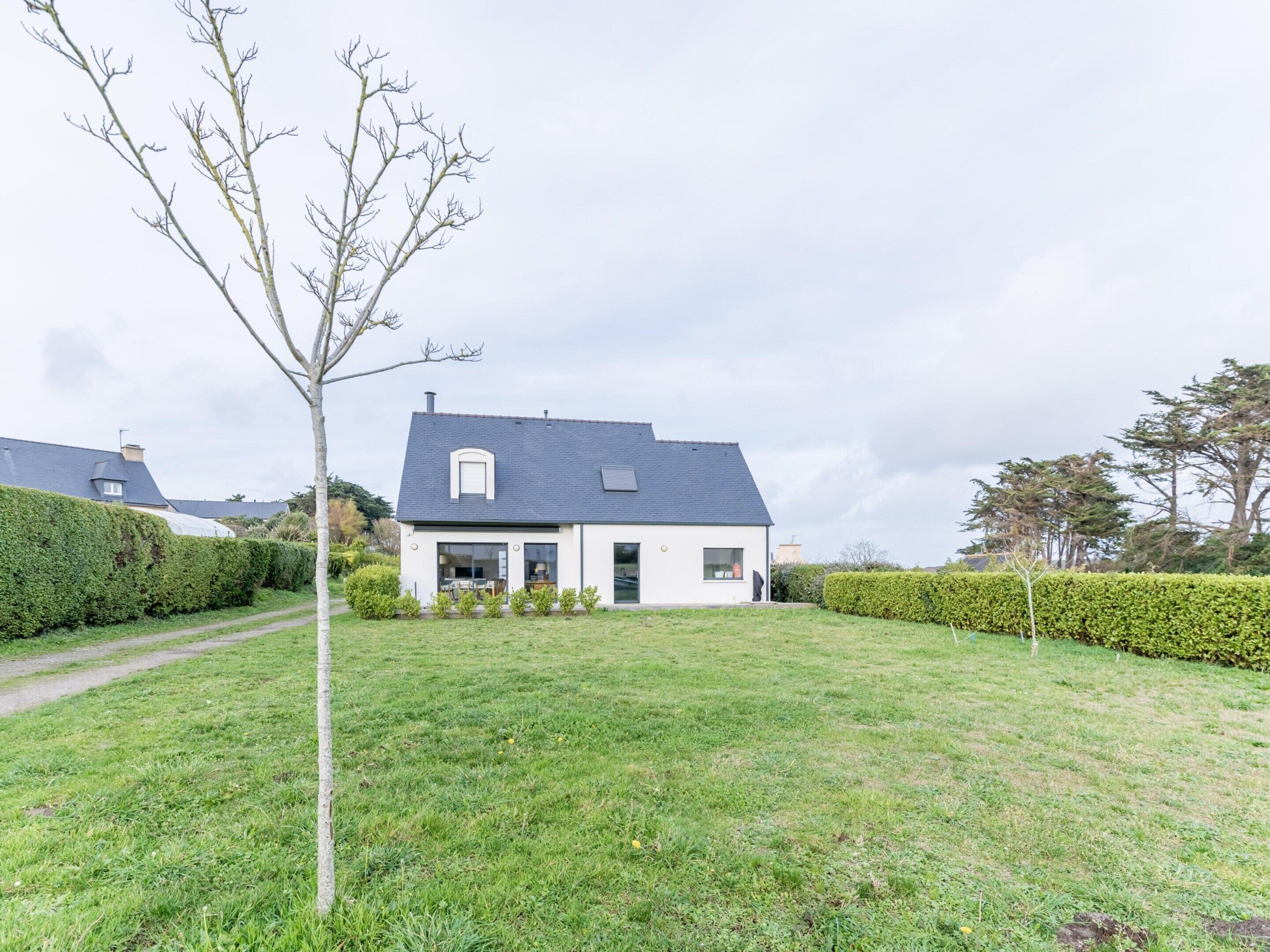 A modern house with a sloped roof, a small front porch, and a well-maintained lawn.