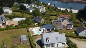 Vista aérea de uma área residencial com casas, piscina e um cais para barcos.