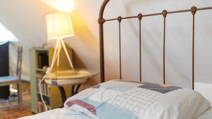 A bed with a quilted pillow and a metal headboard. - Courtgain Guest Rooms in Saint-Valery-sur-Somme (Saint-Valery-sur-Somme)