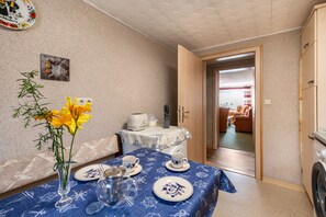 Ein kompakter Wohnbereich mit Essplatz, einer Küchenzeile und Blick in das Wohnzimmer.