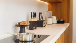A modern kitchen with a countertop, a bowl of snacks, a coffee maker, and a toaster. - An Endless Summer (Marseille)
