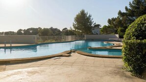A swimming pool with a tiled deck and a fence. - An Endless Summer (Marseille)