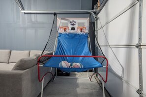 Ein Basketballkorb mit Netz, einem blauen gepolsterten Bereich und einem roten Metallrahmen.