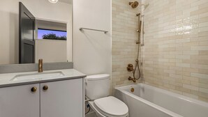 A bathroom with a toilet, sink, and bathtub. - Charming studio in Seattle perfect for your city getaway (Seattle)