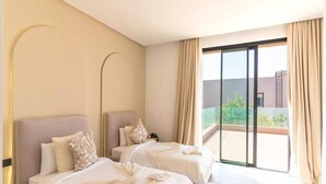 A hotel room with two beds, a large sliding glass door to a balcony, and a view of greenery outside. - Palais Eden (Marrakech)