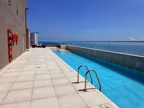 A swimming pool with a glass barrier, lifebuoys, and a clear view of the ocean. - Caribbean Deluxe • Pool, Views & WiFi (Cartagena)