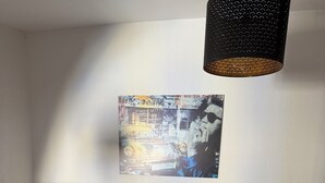 Una escala amb barana negra, una cadira de plàstic transparent amb seient mullat i un cubell de metall, i una làmpada penjada a la paret.