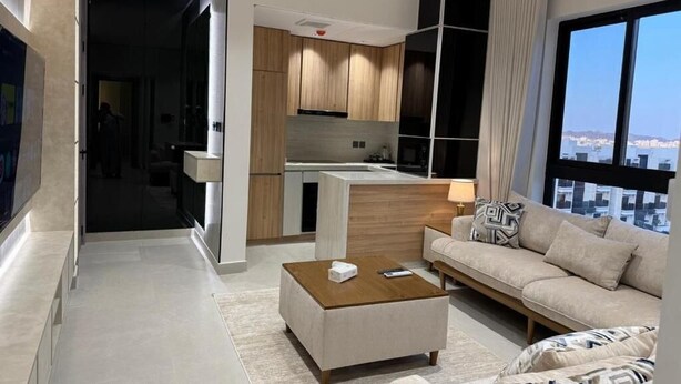 Un salón moderno con sofá, mesa de centro y vista a la ciudad.