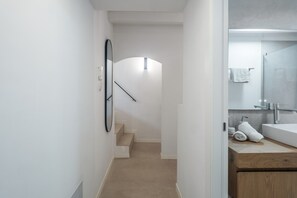 Un bany modern amb un mirall gran, un lavabo i una zona de dutxa.