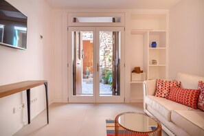Een moderne woonkamer met een bank, een salontafel en een schuifdeur naar een buitenruimte.