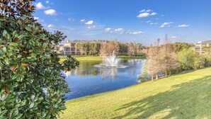 A serene park with a pond, a fountain, and buildings in the background. - Beautiful Condo With Pool, hot Tub, Central AC & W/D - Short Drive to Disney (Davenport)