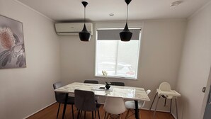 Un espace repas comprenant une table, des chaises et une chaise haute.