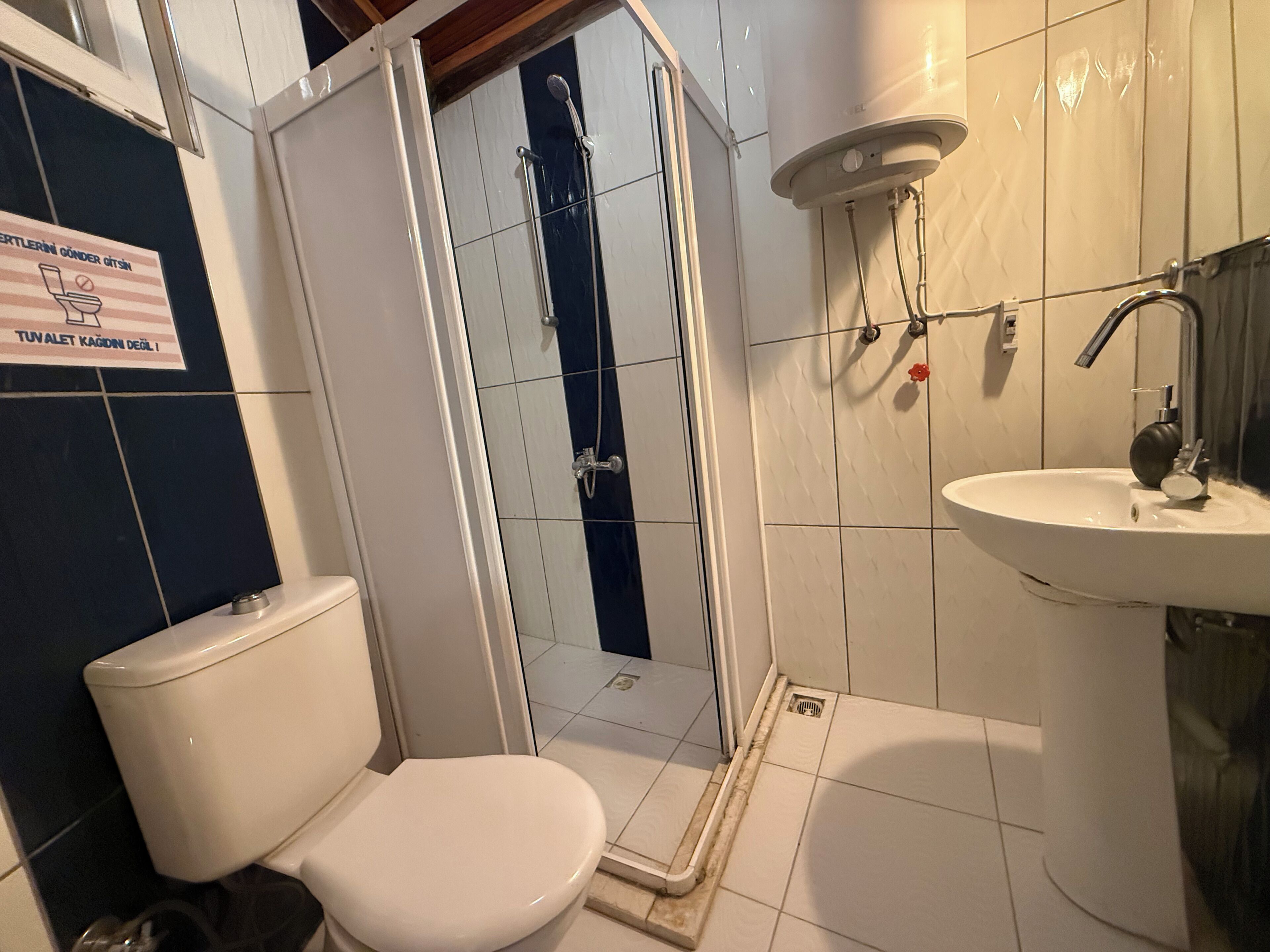 A bathroom with a toilet, a shower enclosure, and a sink.