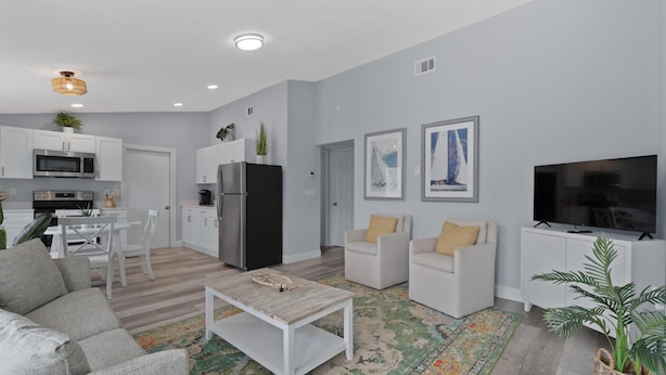 A modern living room with a sofa, coffee table, and TV. - Dune Your Thing C (Fort Myers Beach)