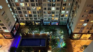 A high-rise building with multiple floors, balconies, and illuminated windows. - SKYHOME Apartment (Ho Chi Minh City)