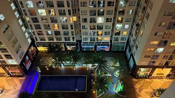 Un edificio alto con varios pisos, balcones y ventanas iluminadas.