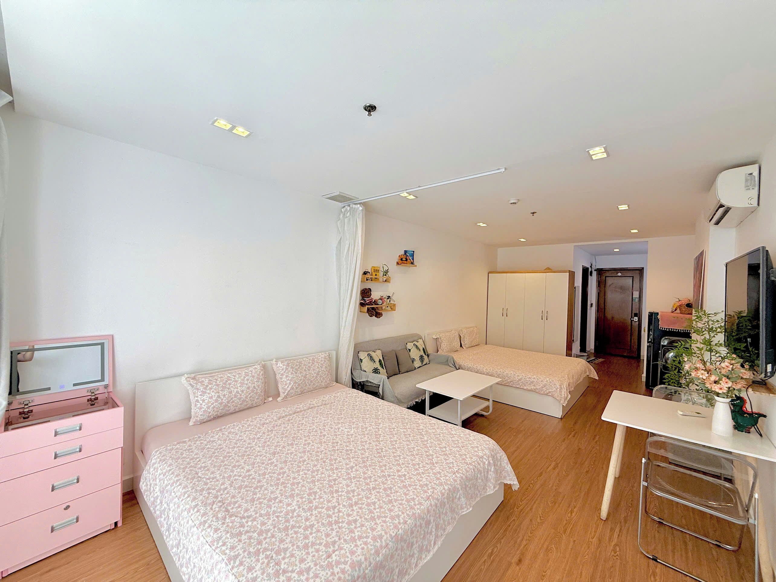 Une chambre à coucher comprenant un lit, un bureau, une chaise, une commode, une armoire et un téléviseur.