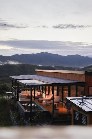 A modern house with a covered outdoor area, including a seating area and a table.