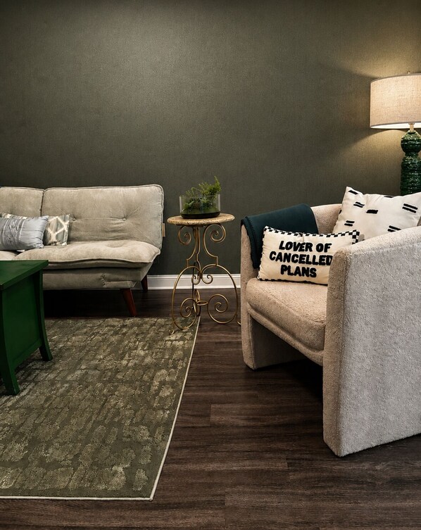 A living room with a sofa, a coffee table, a side table, a lamp, and a rug.