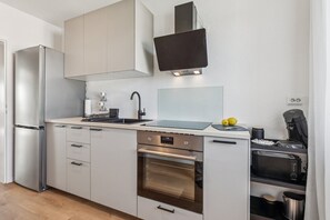 A modern kitchen with a stainless steel refrigerator, a built-in oven, a sink, and a coffee machine. - Modern 90-square-meter apartment | 3 bedrooms | Balcony | Near Phantasialand (Wesseling)